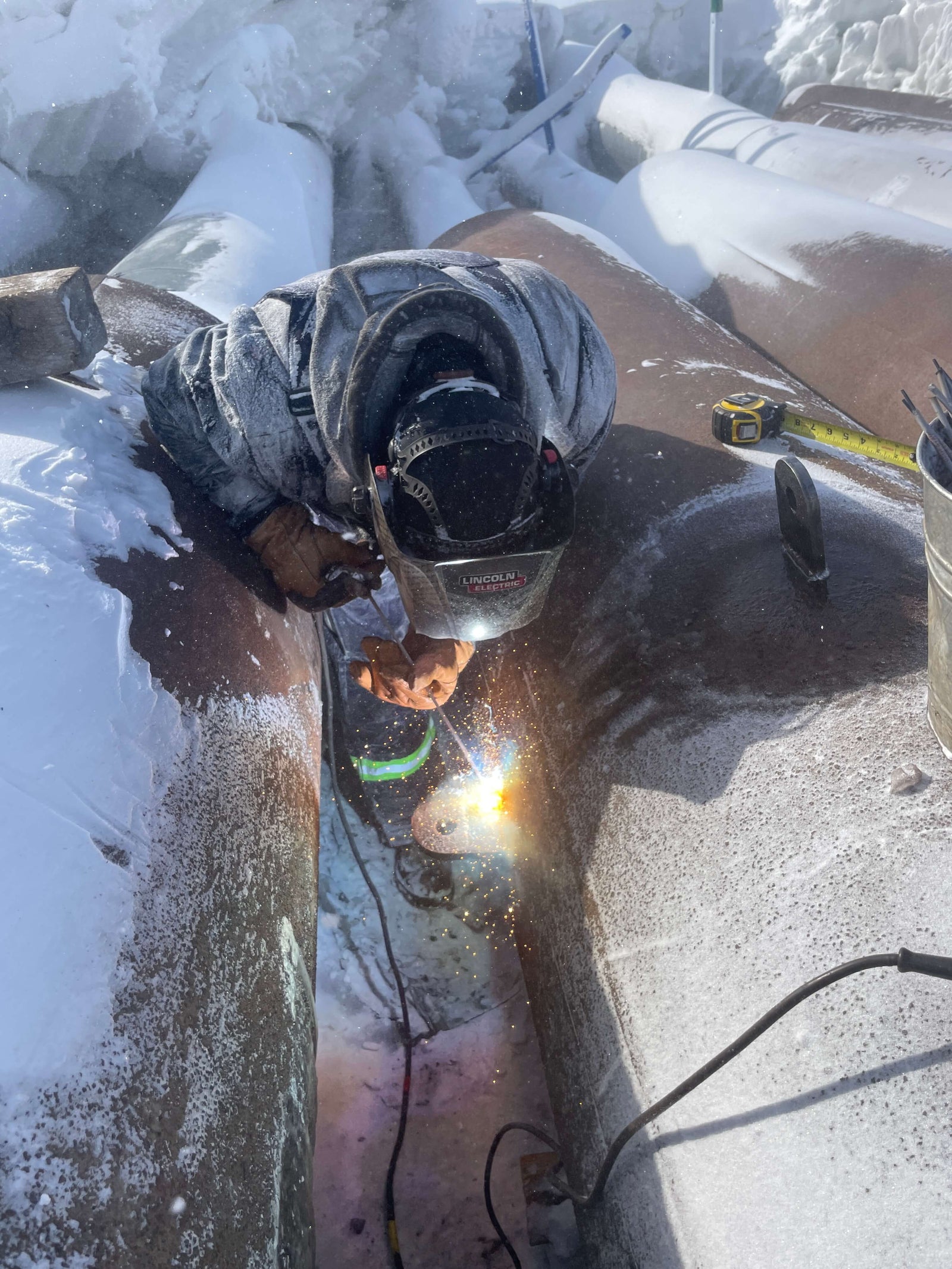 Person welding on a snowy roof