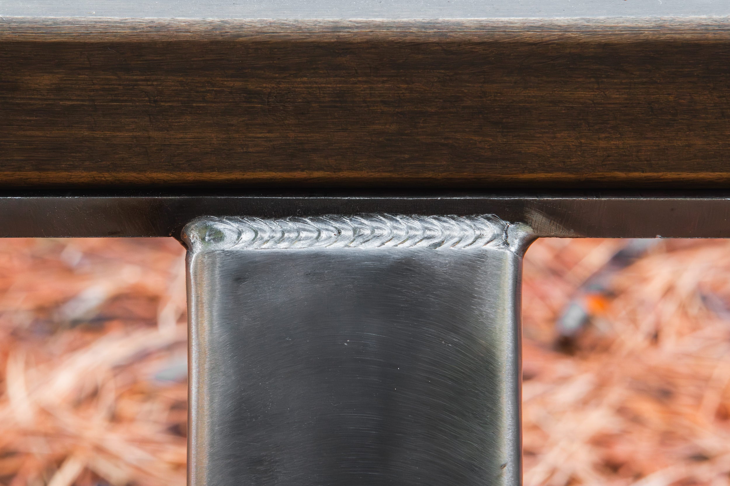 Close-up of a metallic object with a textured surface on a blurred natural background