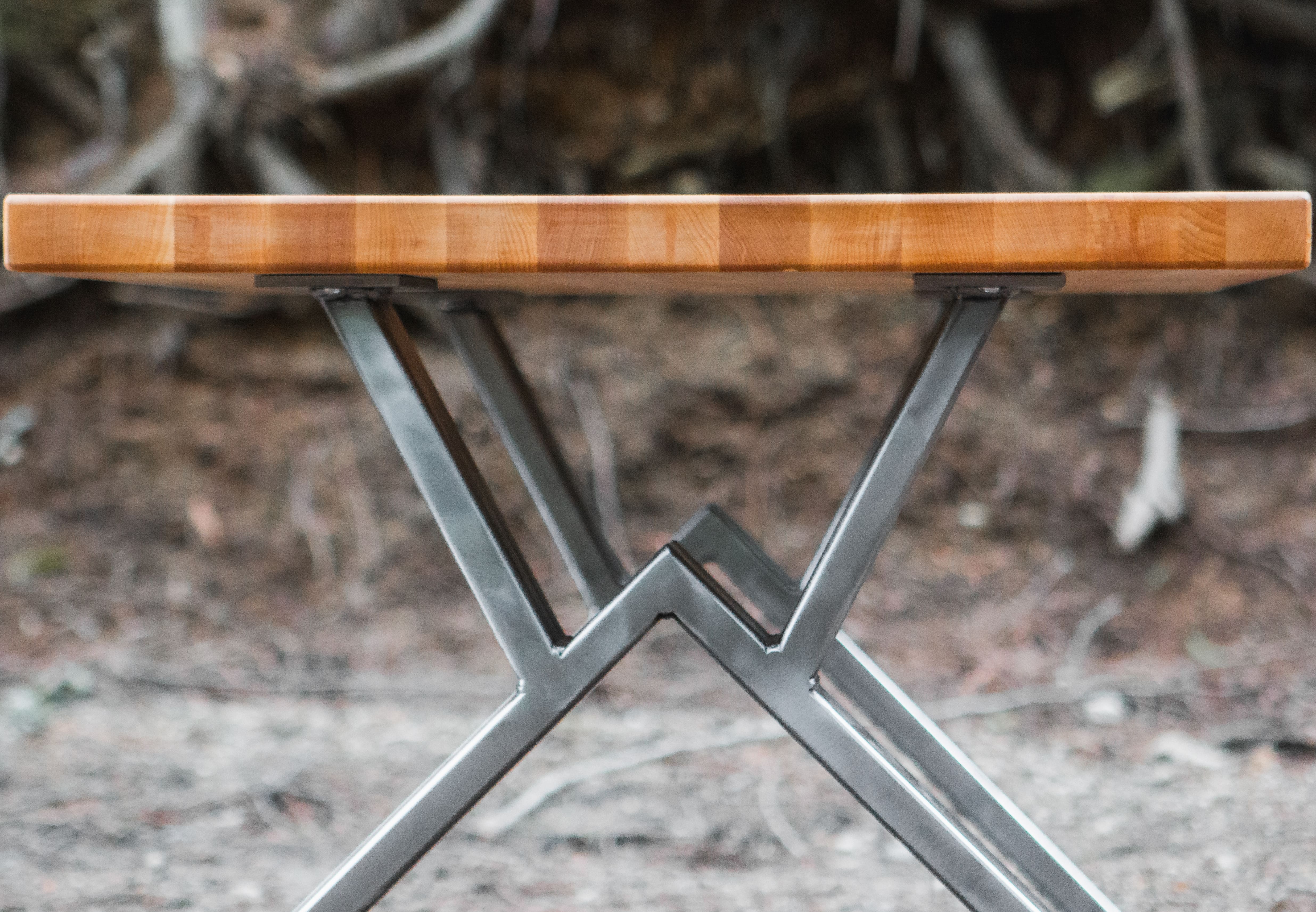 Wooden table with metal legs on a natural background