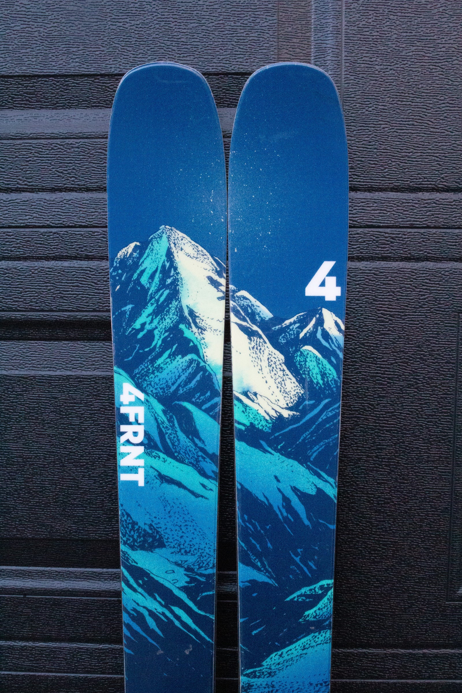 Blue ski with mountain design and '4FRNT' branding against a dark background