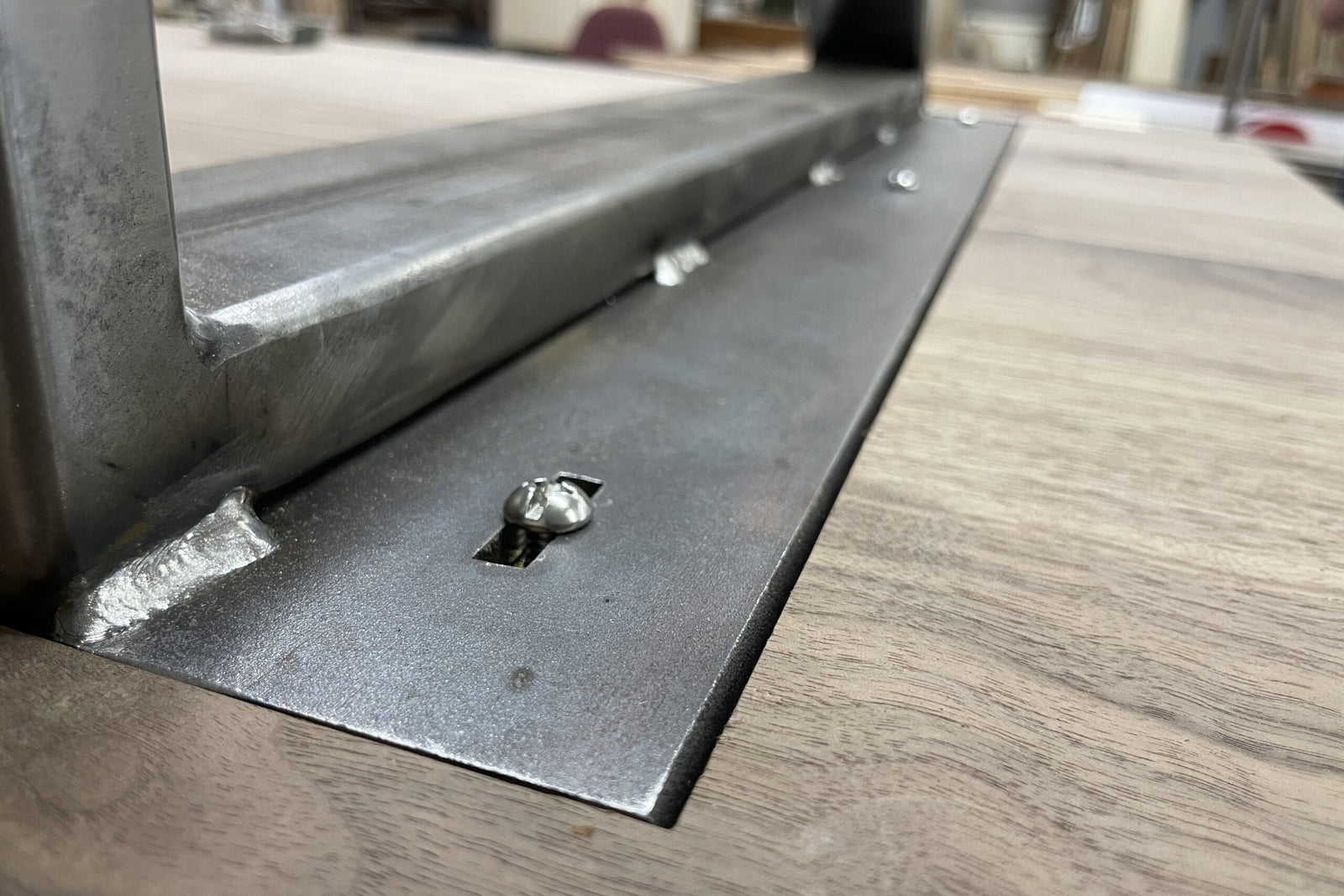 Metal bracket on a wooden surface with blurred background