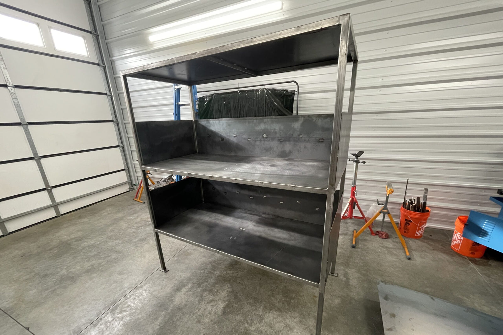 Metal workbench in a garage setting with tools and equipment around
