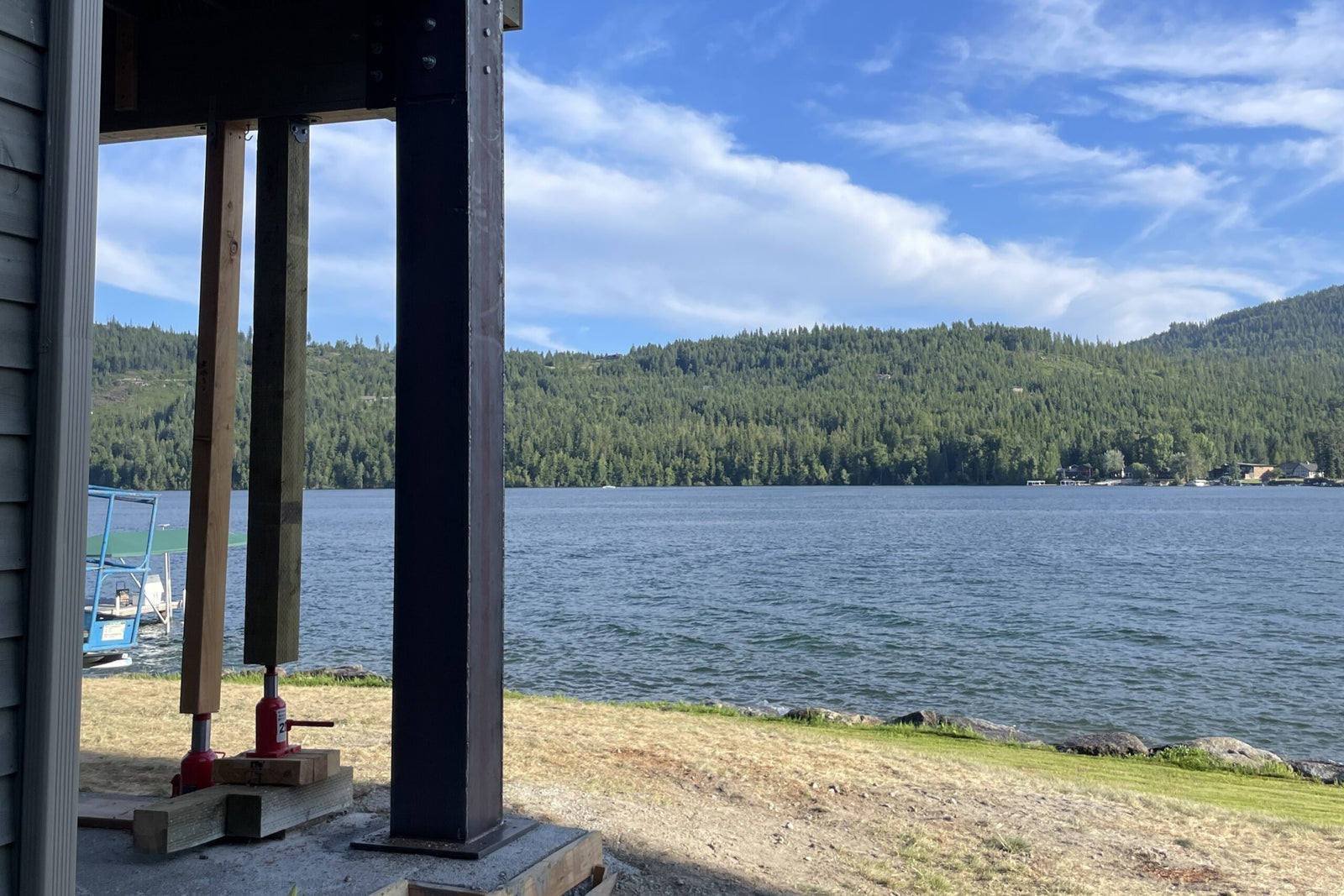 View of a lake with a cabin and dock in the foreground