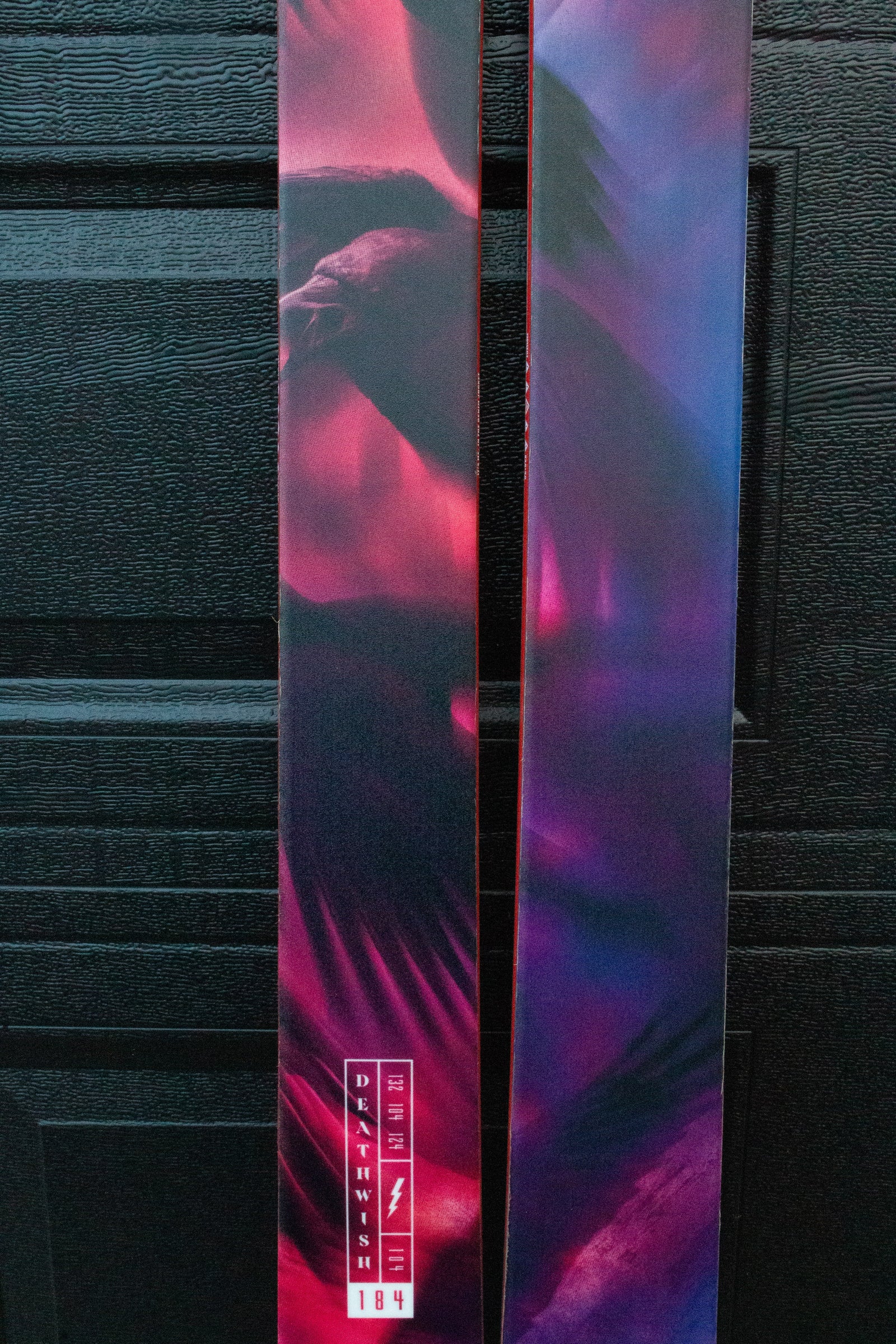 Colorful skis with abstract design against a dark background