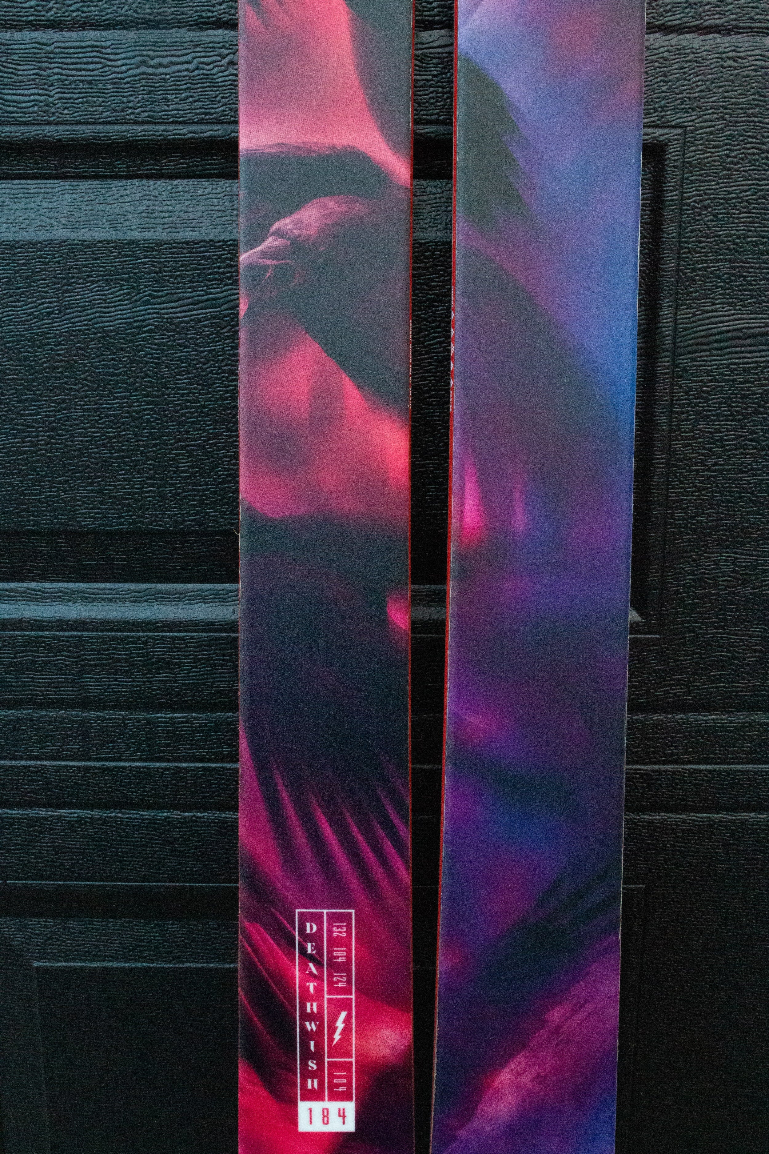 Colorful skis with abstract design against a dark background