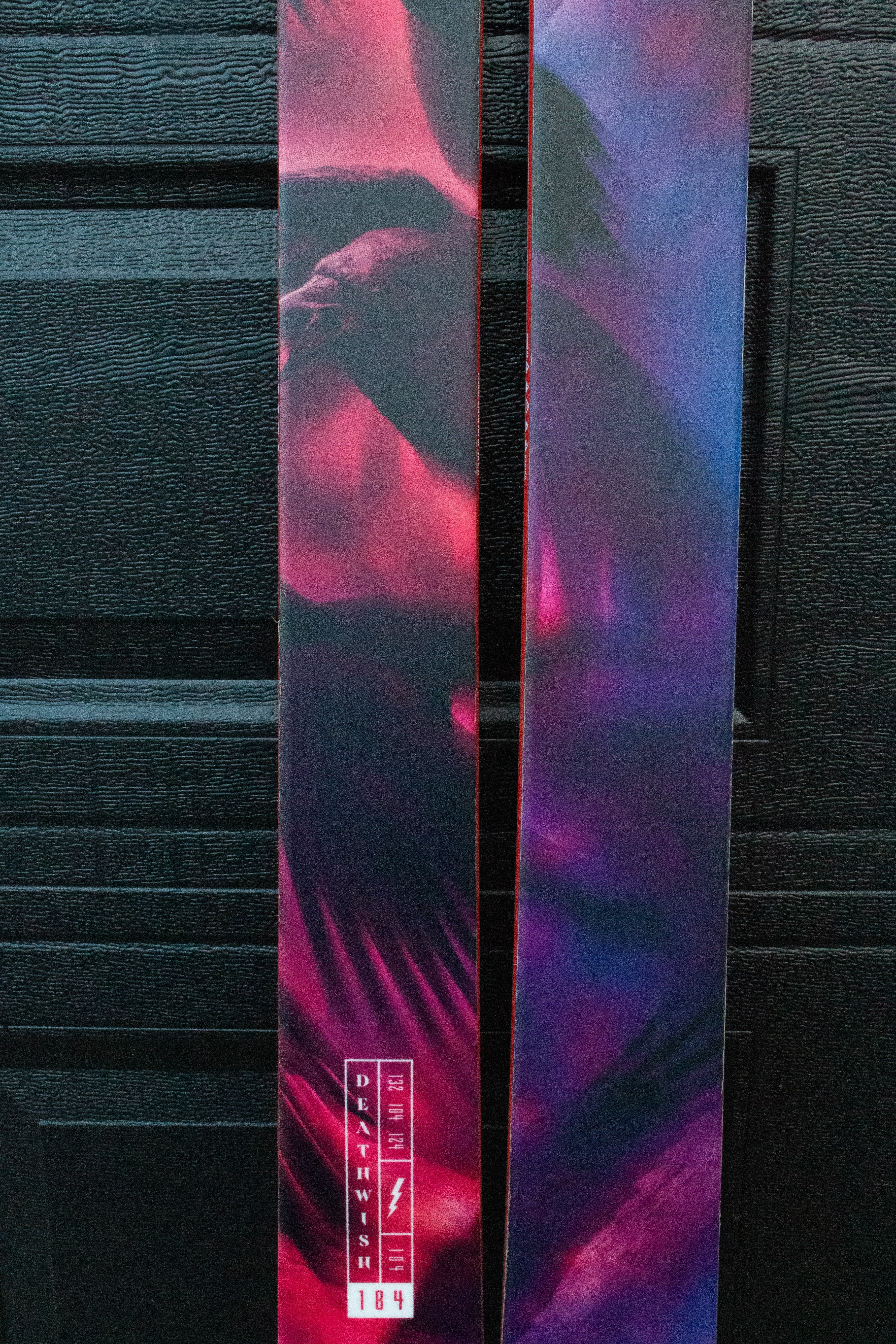 Colorful skis with abstract design against a dark background