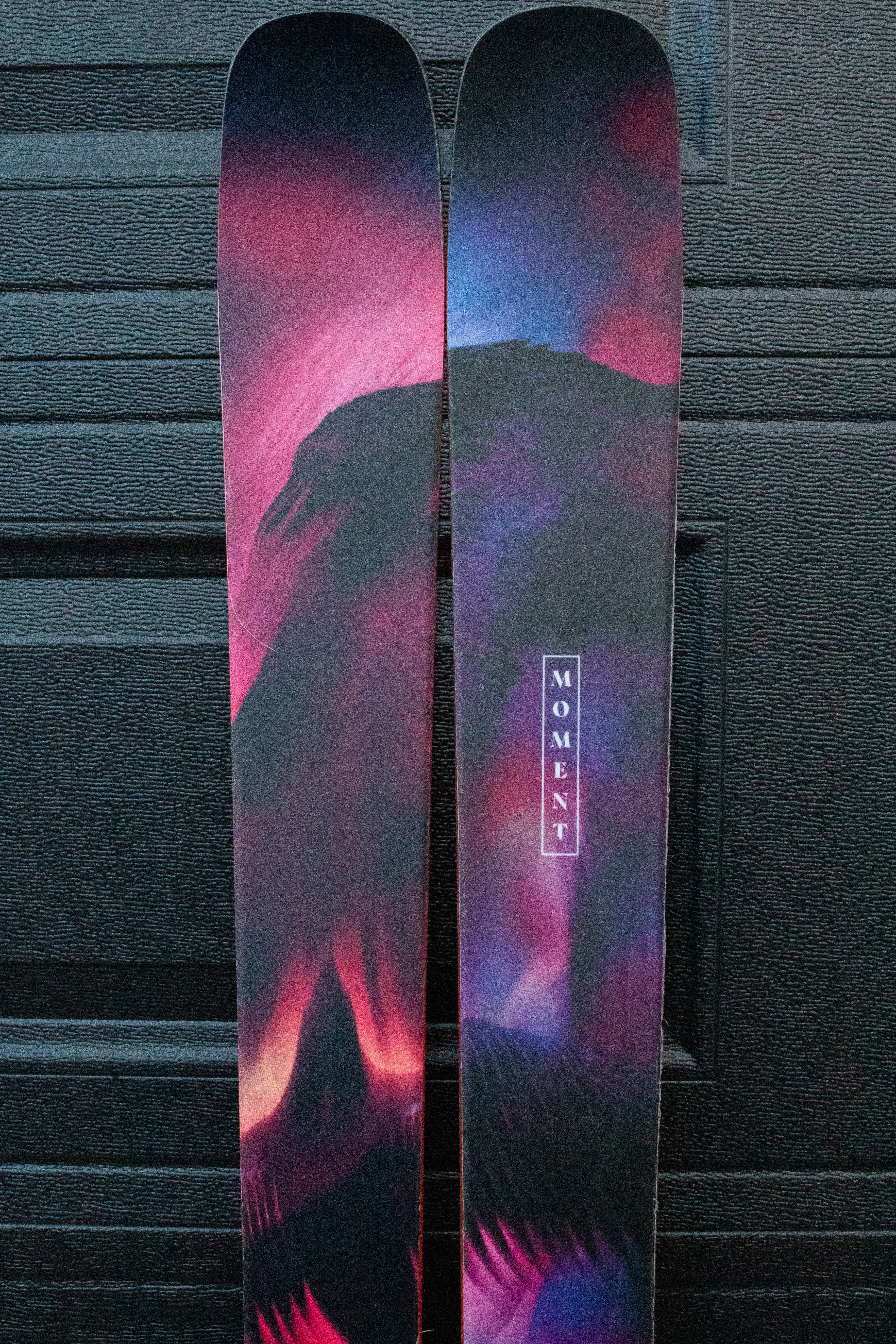 Pair of skis with a colorful design on a dark background