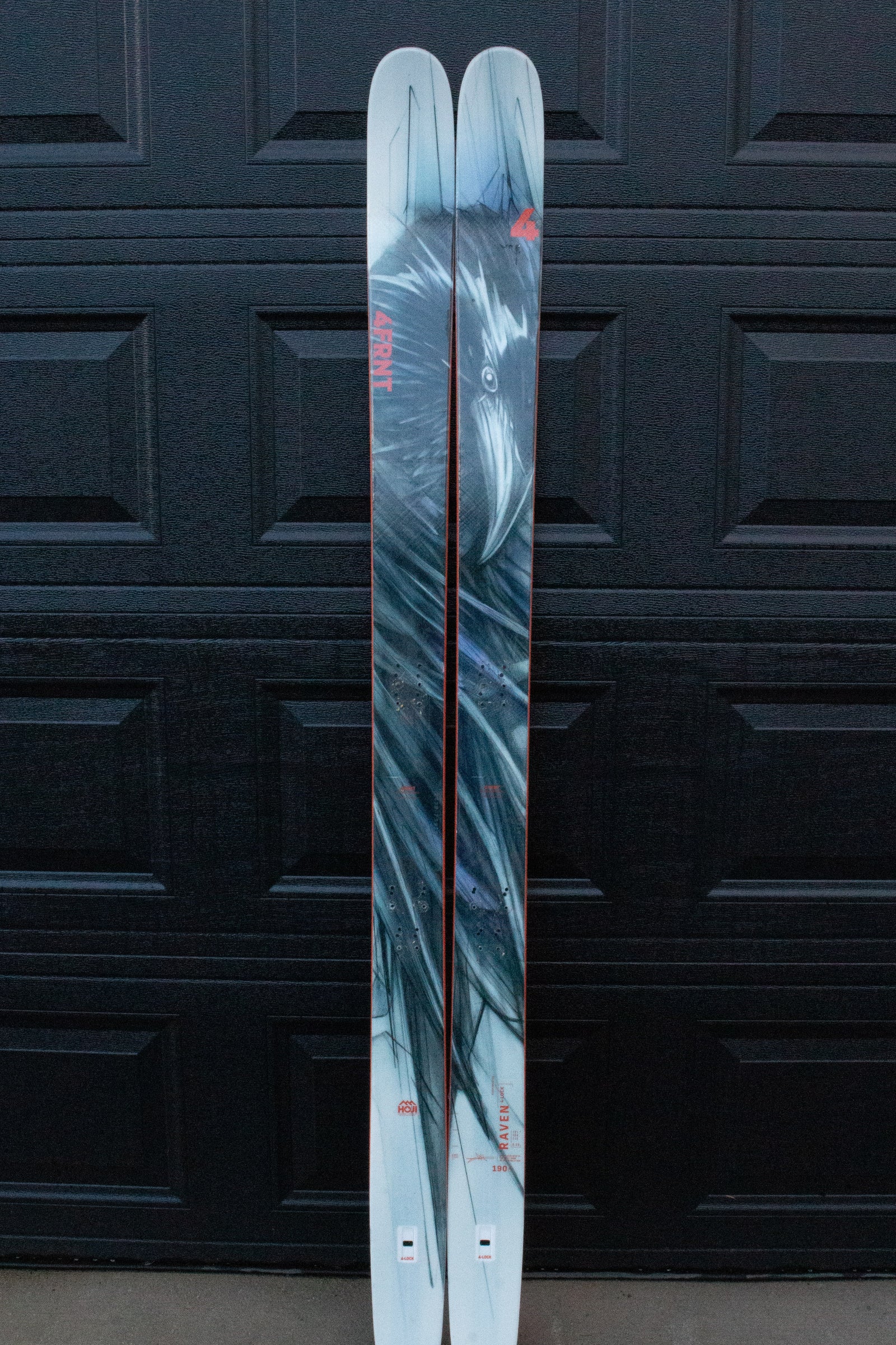 Pair of skis with a black and gray pattern on a black textured background