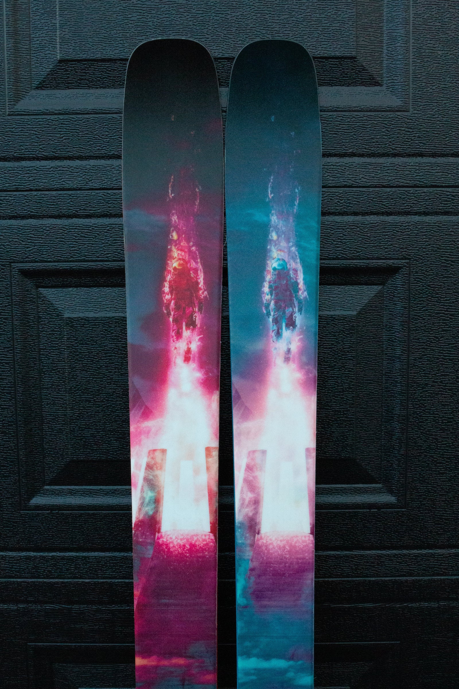 Colorful skis with a vibrant design on a textured black background